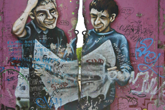 A piece of graffiti art that now covers a section of the Berlin Wall. The physical break in the wall has been incorporated into the art.