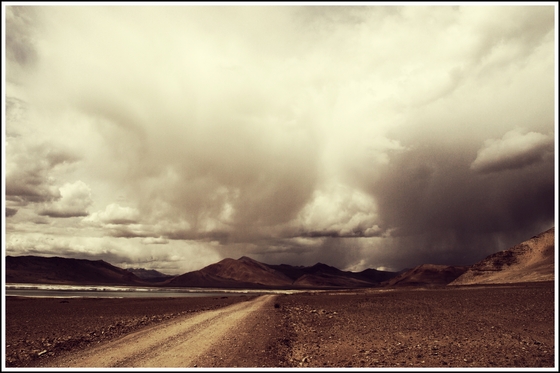 Ladakh is a high altitude desert located in the middle of the Himalayas, adjoining Tibet. By "high" I mean the average height here is 12,500 feet. This image is a view of Tso Kar, "Tso" meaning lake and the path you see on the left is the "road" leading to the camp-site where we spent the night. Tso Kar is located at an altitude of 14,000 feet and breathing here was difficult, thought not as much as in Tso Moriri. The landscape is arid and desert scrub and the lake itself is salt water and filled with brine. Its a great location for wildlife sightings and my Photography group took photos of the Kiang or Tibetan Ass, Brahmini Duck, Marmots, Golden Eagle amongst others.  

"Changthang" means Northern Plains in Tibetan as this plateau is an extension of the Tibetan Plateau that starts further to the east. 